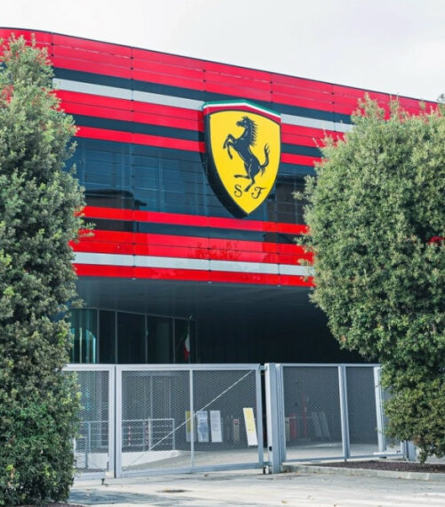 Здание в красных и черных цветах с крупным логотипом автомобильной компании на фасаде.