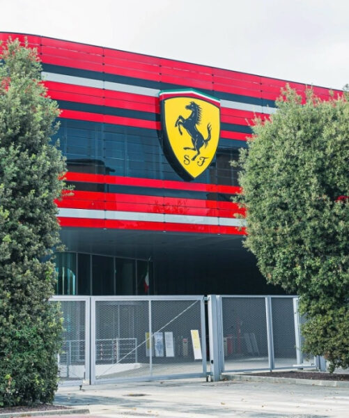 Здание в красных и черных цветах с крупным логотипом автомобильной компании на фасаде.