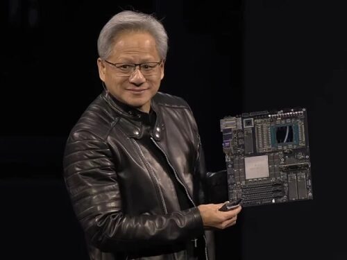 Человек в кожаной куртке демонстрирует компьютерную плату.