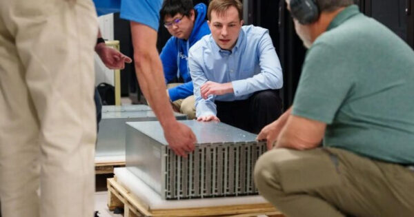 Люди устанавливают серверное оборудование в дата-центре.