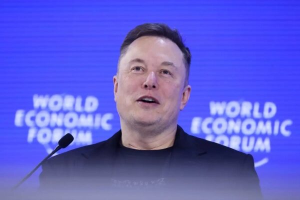 Человек с микрофоном на фоне логотипа Всемирного экономического форума.