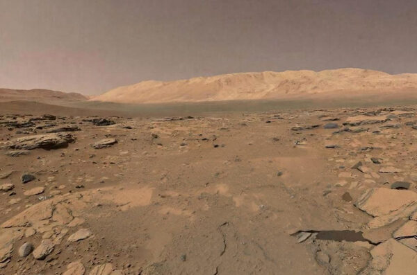 Поверхность Марса, пустынный ландшафт с камнями и пыльной атмосферой.