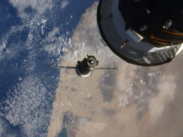 Спутник и Земля из космоса: вид на облака и поверхности планеты.