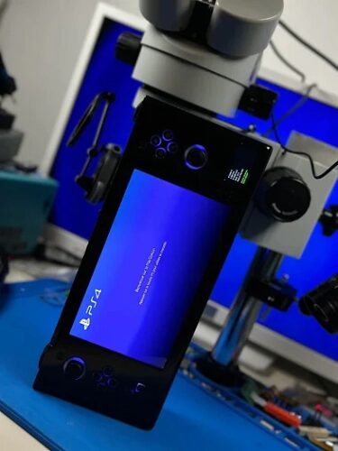 Ручная консоль PS4 перед микроскопом на рабочем столе.