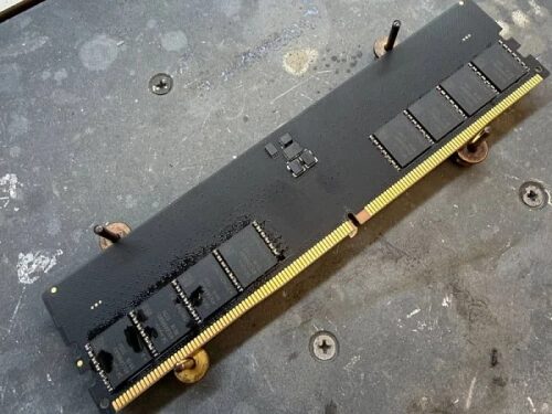 Повреждённая планка оперативной памяти на чёрном столе.