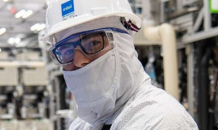 Человек в защитном костюме на фабрике Intel, производство микрочипов.