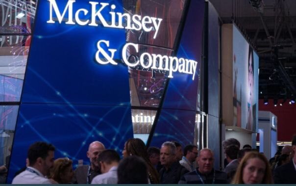 Стенд McKinsey & Company на бизнес-мероприятии с толпой людей вокруг.