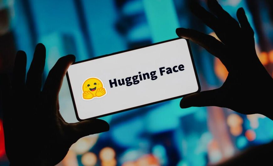 Смартфон с логотипом и надписью "Hugging Face" на размытом фоне.