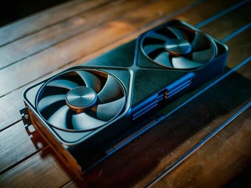Видеокарта с двумя вентиляторами на деревянном столе, крупный план.