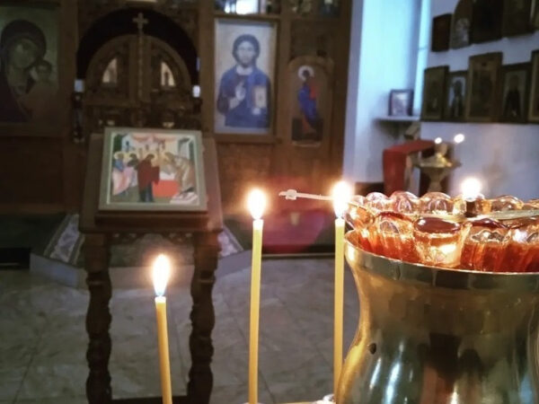 Свечи перед иконами в православной церкви, атмосфера молитвы и духовности.