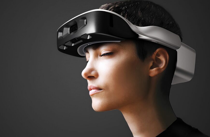 Человек в VR-гарнитуре на сером фоне.