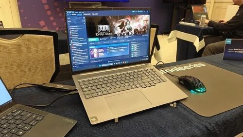 Ноутбук Lenovo с запущенной игрой на экране, мышь Steelseries на столе.