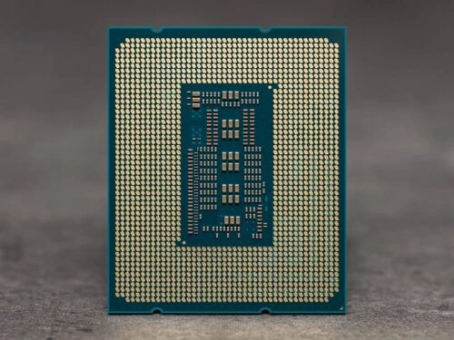 Процессор на сером фоне, вид снизу, золотые контакты на зелёной плате.