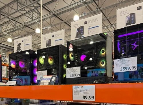 Компьютеры на витрине магазина с ценниками и подсветкой внутри.