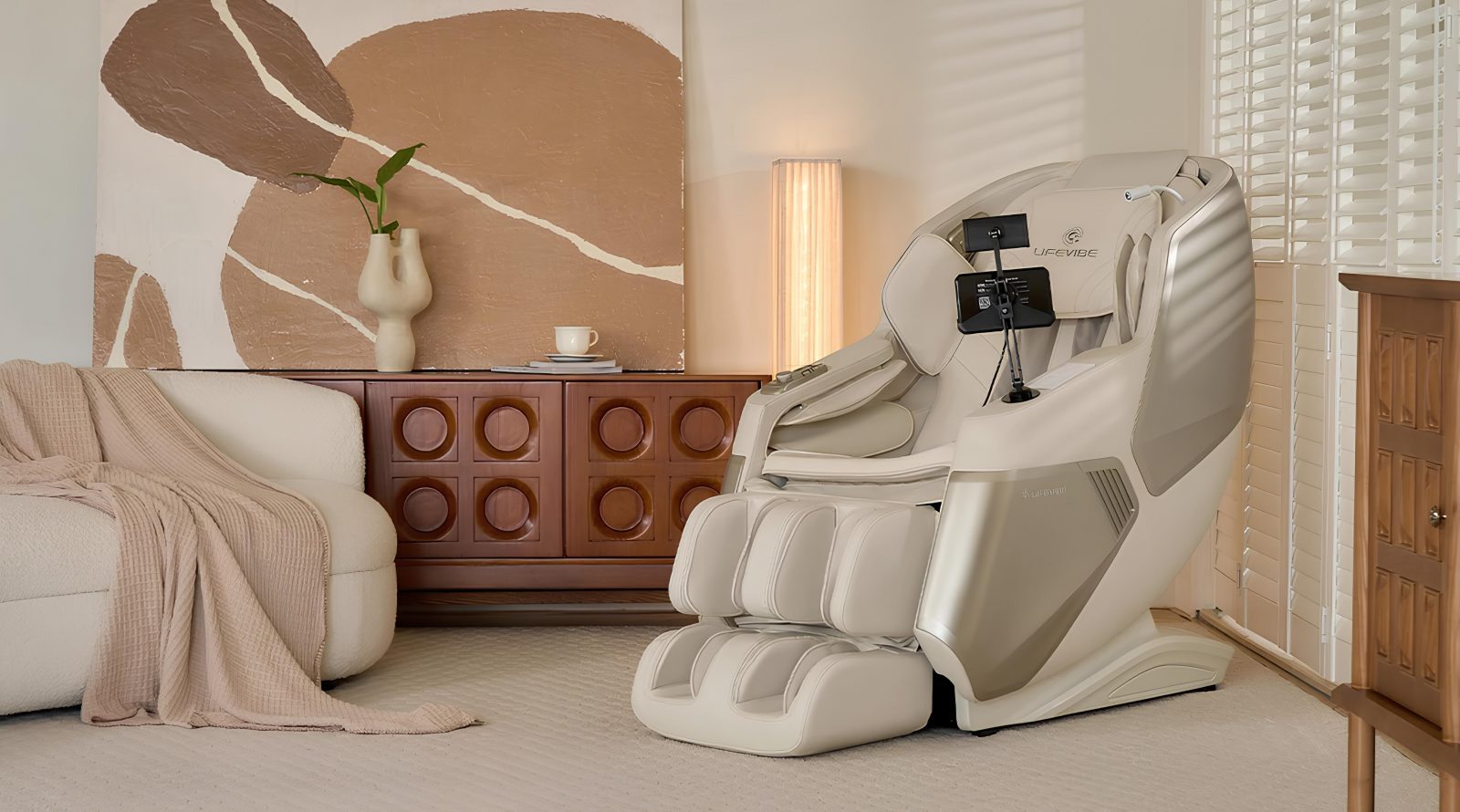 Массажное кресло Lifevibe Prime лечит звуком 12 Массажное кресло в современном интерьере гостиной, рядом диван и картина на стене.