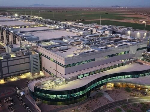 Завод в сумерках с современными зданиями и оборудованием.