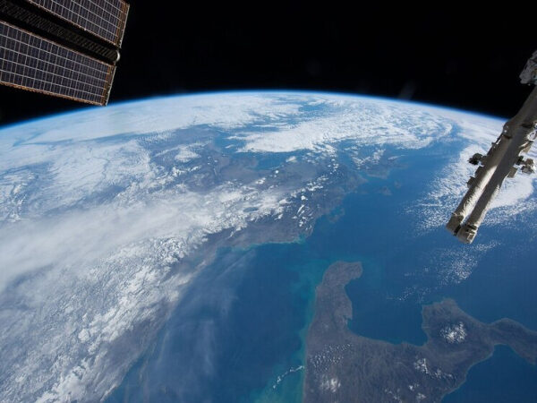 Вид на Землю из космоса с элементами МКС на переднем плане.