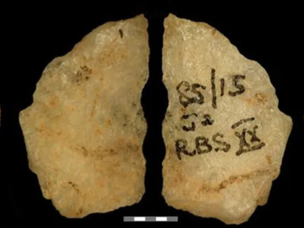 Древний каменный артефакт с надписями на черном фоне.