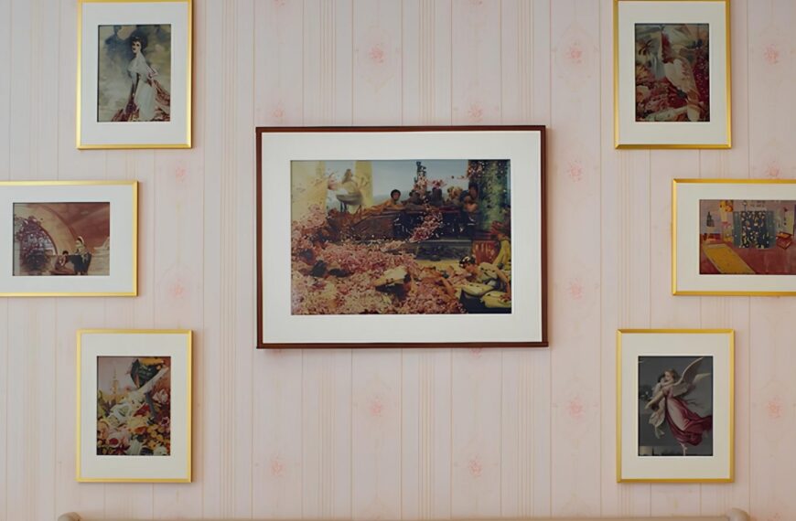 Галерея из шести картин в золотистых рамах на светло-розовой стене.