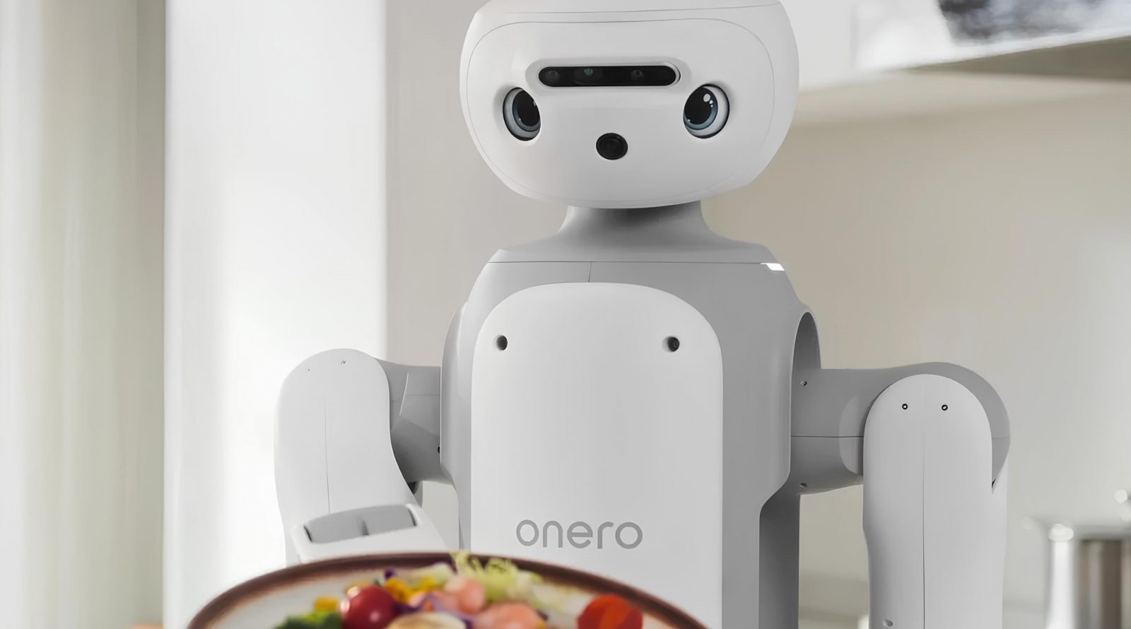 Белый робот с камерой, держащий тарелку с овощами на кухне.