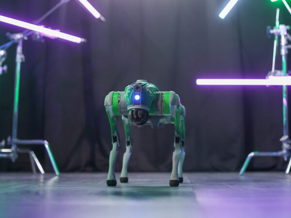 Робот-собака на сцене под неоновым светом.