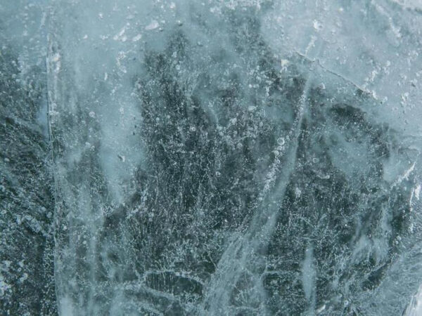 Текстура льда крупным планом с трещинами и пузырьками воздуха.