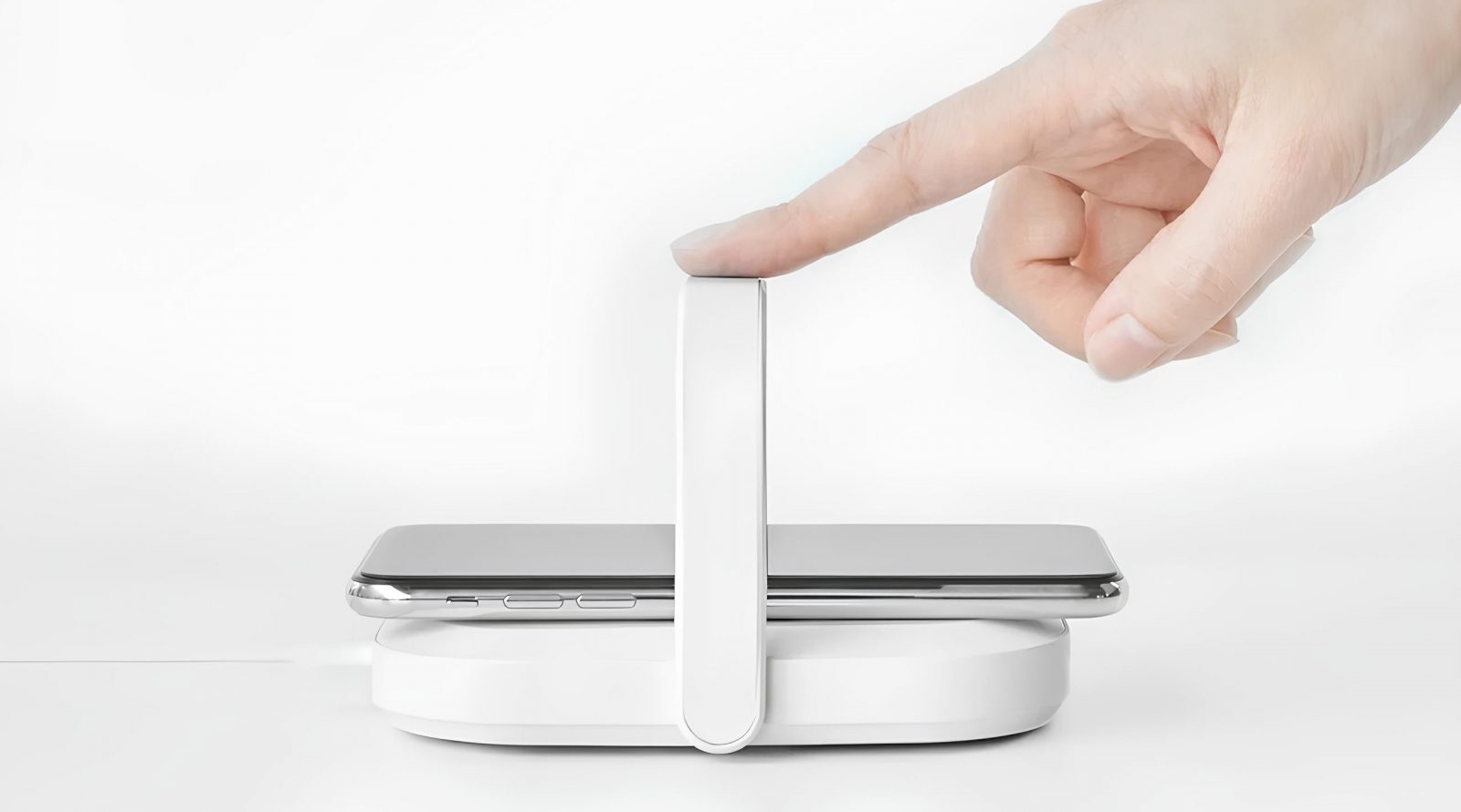 Беспроводная зарядка телефона, рука активирует устройство.