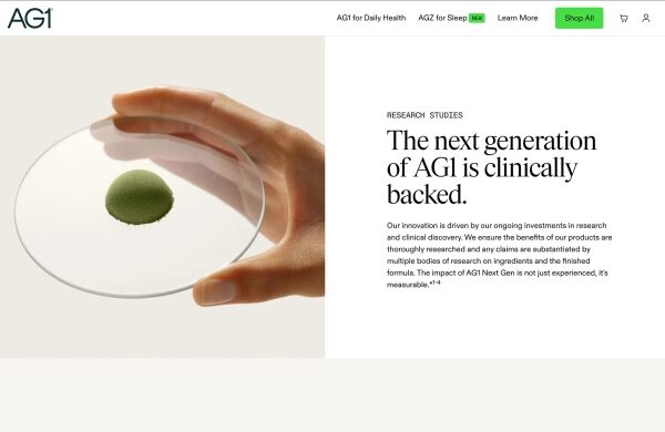Скриншот страницы исследования AG1, где говорится: «Клинические исследования AG1 следующего поколения подтверждены», и изображена рука, держащая диск, напоминающий чашку Петри, с горкой зеленого порошка в центре.