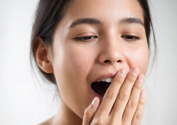 Женщина с темными волосами на светлом фоне, обращена вполоборота.