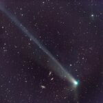Комета с длинным хвостом на фоне ночного звёздного неба.