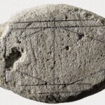 Древний камень с геометрическими рисунками и узорами, археологический артефакт.