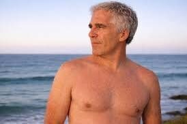 Мужчина с седыми волосами на пляже у моря на фоне заката.