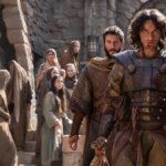 Сцена из фэнтези-фильма: рыцари в броне на фоне средневековой архитектуры.