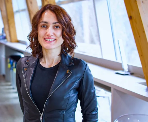 Долгожданное доказательство укрощает некоторые из самых непослушных математических уравнений. 2 Женщина в черной кожаной куртке улыбается.