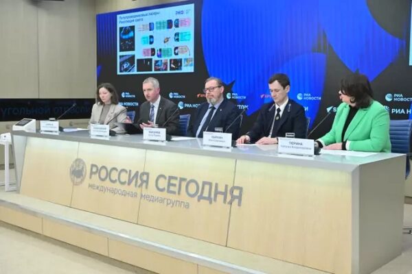 Пресс-конференция в «Россия Сегодня», выступают представители на фоне экрана с графиками.