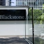 Вывеска компании Blackstone на фоне городского пейзажа.