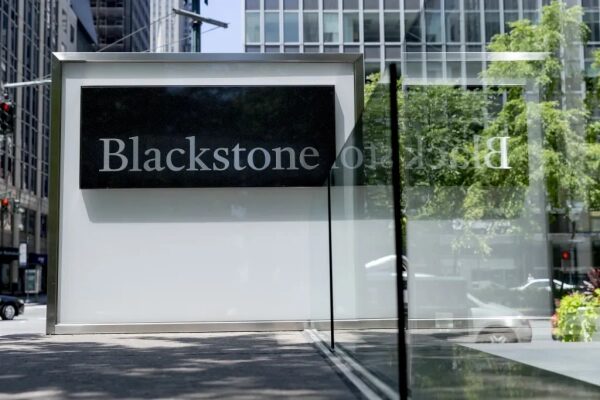 Вывеска компании Blackstone на фоне городского пейзажа.