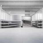 Современный завод с крупным оборудованием и высокими потолками внутри просторного помещения.