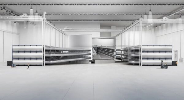 Современный завод с крупным оборудованием и высокими потолками внутри просторного помещения.