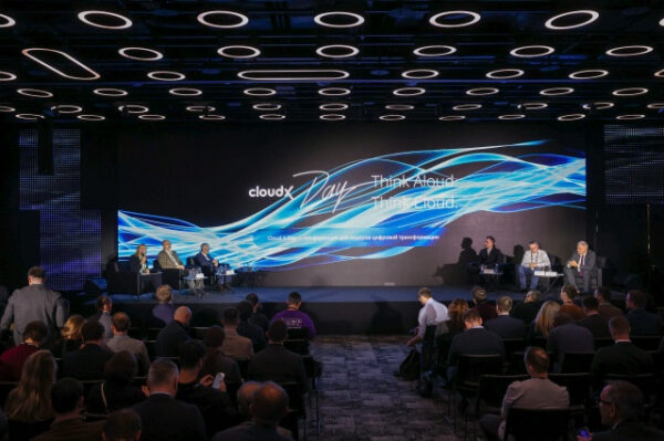 Конференция CloudxDay с участием спикеров на сцене и зрителей в зале.
