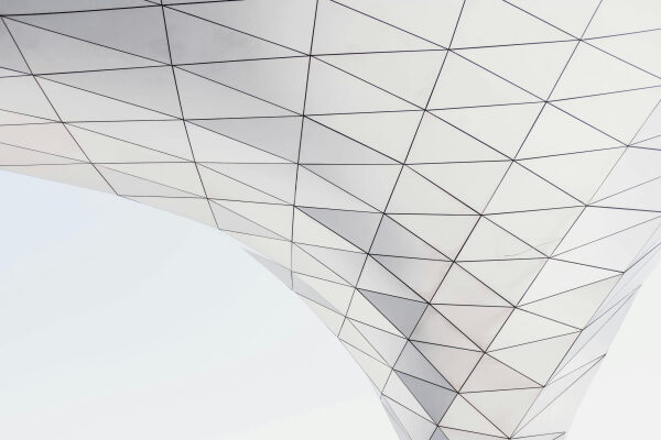 Современная архитектурная структура с геометрическим узором на фоне неба.