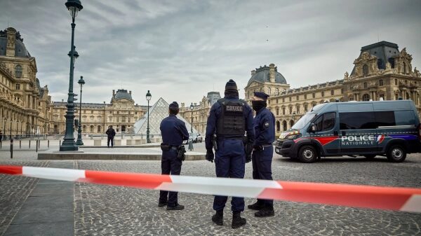 Парижская полиция уходит территорию Лувра, патруль и оцепление перед музеем.