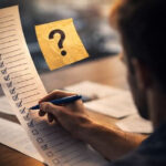 Мужчина заполняет длинный список задач, рядом значок вопроса.