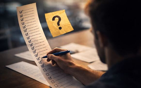 Мужчина заполняет длинный список задач, рядом значок вопроса.