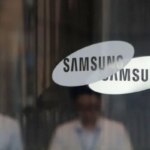 Логотип Samsung на стеклянной двери офисного здания.