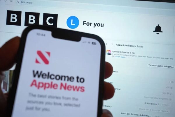 Человек держит телефон с Apple News, на фоне сайт BBC в браузере.