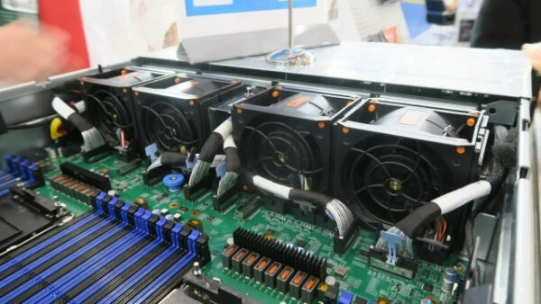 Внутренности серверного оборудования с вентиляторами и компонентами на зеленой плате.