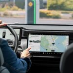 Водитель использует навигацию на экране автомобиля с картой и маршрутом.