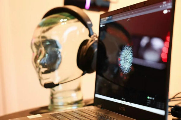 Ноутбук с изображением отпечатка пальца, рядом стеклянная голова с наушниками.