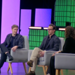 Трое людей на сцене участвуют в обсуждении на конференции.